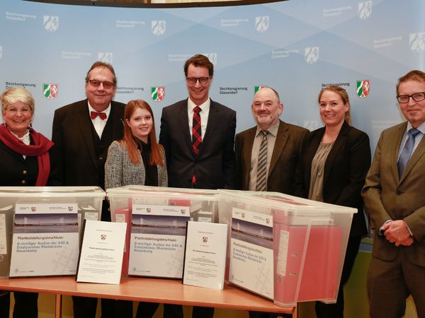 Landesverkehrsminister Hendrik Wüst (M.) und Birgitta Radermacher (l.) mit dem Team des Dezernats 25 der Bezirksregierung und Udo Pasderski (r., DEGES)