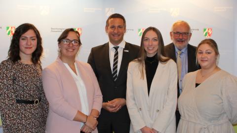 Erklärfilm-Wettbewerb 2023 ZfsL 3. Platz: Lehramtsanwärterinnen des Zentrums für schulpraktische Lehrerausbildung Oberhausen mit Regierungspräsident Thomas Schürmann (Mitte) und Abteilungsdirektor Thomas Hartmann