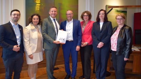 Regierungspräsident Thomas Schürmann überreicht den Förderbescheid an Herrn Uwe Schneidewind, Oberbürgermeister der Stadt Wuppertal.