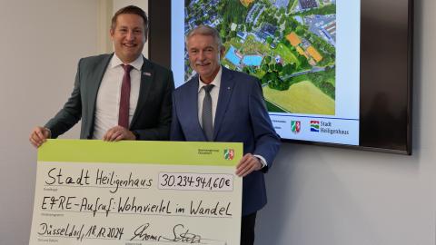 Regierungspräsident Thomas Schürmann übergibt Bürgermeister Michael Beck den Förderbescheid.