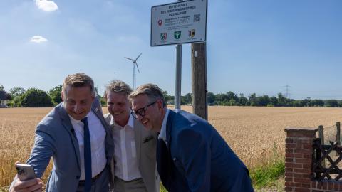Regierungspräsident Thomas Schürmann, Bürgermeister Christoph Fleischhauer und Landrat Ingo Brohl (v.l.) machen ein Foto am Mittelpunkt des Regierungsbezirks.