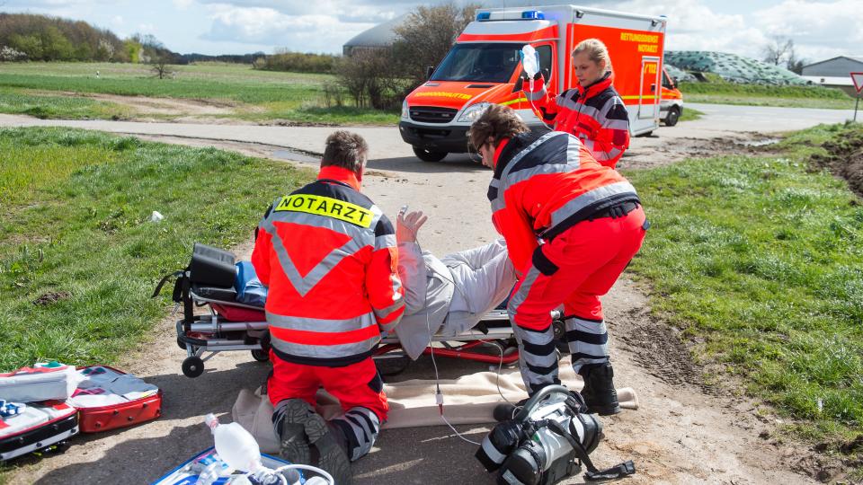 Rettungsdienst und Notarzt versorgen schwer kranken Mann an einer Einsatzstelle