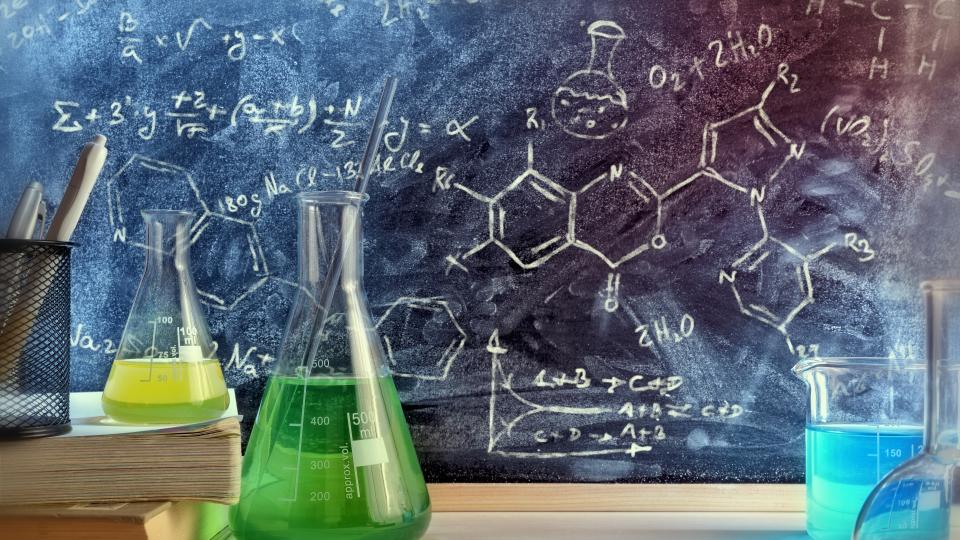 Klassenzimmer Schreibtisch und gezeichnete Tafel des Chemieunterrichts mit Büchern und Instrumenten. Konzept der Ausbildung in den chemischen Wissenschaften. Horizontale Zusammensetzung. Vorderansicht