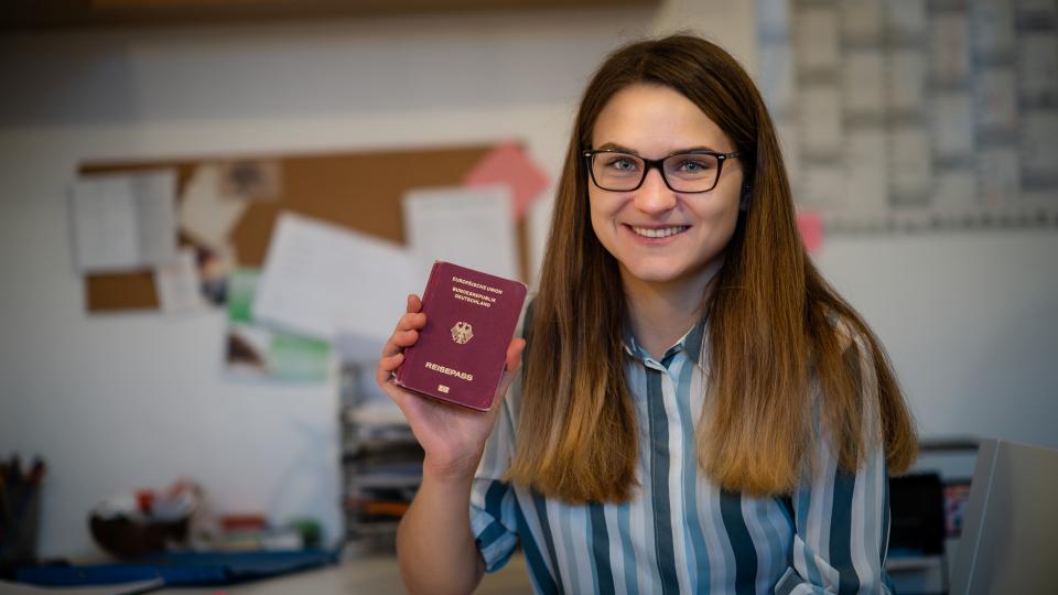 Junge Frau zeigt ihren Reisepass