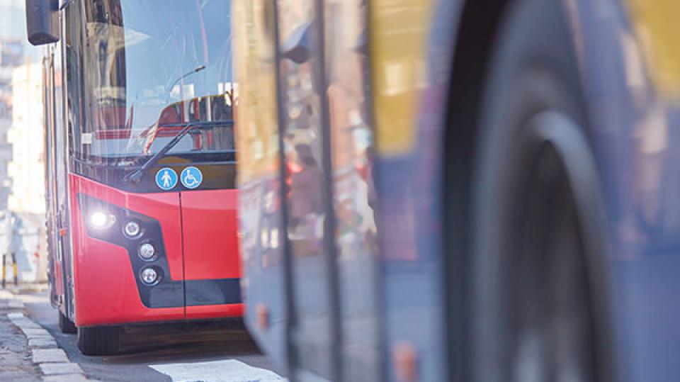 Öffentliche Verkehrsmittel / Bus in städtischer Umgebung an einem Bahnhof.