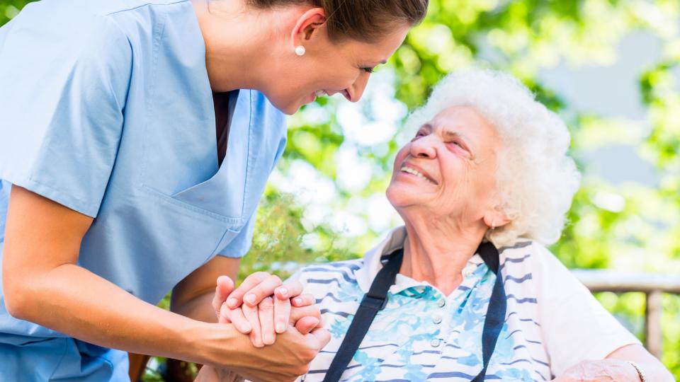Altenpflegerin hält die Hand einer Seniorin (Symbolbild)