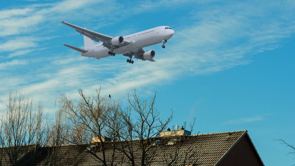 Flugzeug im Landeanflug über einem Haus (Symbolbild)