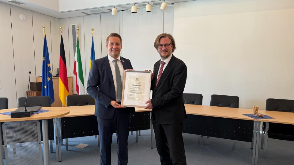 Regierungspräsident Thomas Schürmann überreicht Bürgermeister Dominik Pichler die Urkunde, die die Stadt als Ort mit Heilquellenkurbetrieb auszeichnet.