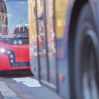 Öffentliche Verkehrsmittel / Bus in städtischer Umgebung an einem Bahnhof.