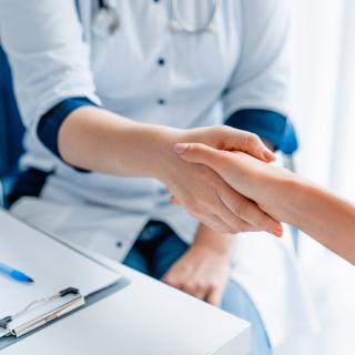 Ärztin gibt Patienten die Hand