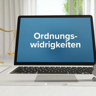 Ordnungswidrigkeiten – Recht, Gesetz, Internet. Laptop im Büro mit Begriff auf dem Monitor. Paragraf und Waage.