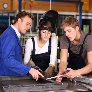 Auszubildende mit Ausbilder bei der Arbeit