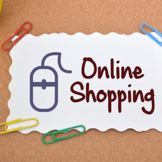 Bunte Büroklammern auf einem Online Shopping Schild (Symbolbild)