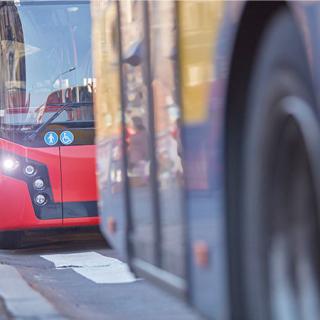 Öffentliche Verkehrsmittel / Bus in städtischer Umgebung an einem Bahnhof.