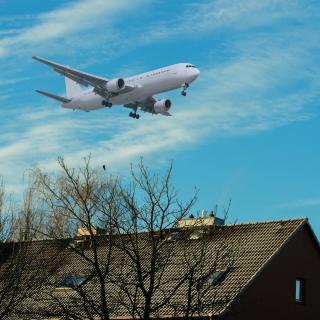 Flugzeug im Landeanflug über einem Haus (Symbolbild)
