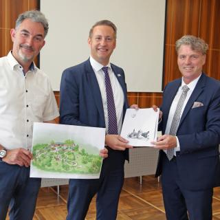 Beigeordneter Thorsten Kamp (li.) und Bürgermeister Christoph Fleischhauer (re.) nahmen den Förderbescheid von Thomas Schürmann (Mitte) entgegen.