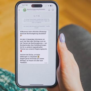 Eine Frau hält ein Handy in der Hand.