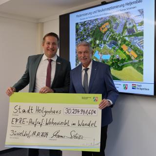 Regierungspräsident Thomas Schürmann übergibt Bürgermeister Michael Beck den Förderbescheid.